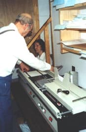 Norm placing a book on a spiral binding machine